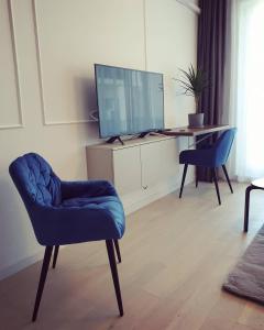 a living room with a tv and a chair and a desk at Blue Record Vibe in Cluj-Napoca