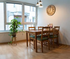a dining room table with chairs and a clock on the wall at Zentrale - Ferienwohnung am Thomaskirchhof in Leipzig