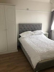 a bedroom with a bed with a white comforter at 3 bed bungalow Penrhyn Bay Llandudno in Llandrillo-yn-Rhôs