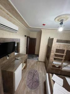 Cette chambre comprend un lit, une télévision et un canapé. dans l'établissement Özgür Hotel, à Antalya
