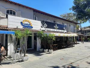 a building with tables and chairs in front of it at Lulu Pousada Buzios in Búzios