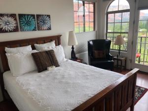 a bedroom with a large white bed and a chair at The Penrose Bed & Breakfast in Sedona