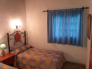 1 dormitorio con cama y ventana azul en Room in Guest room - Casa El Cardon A2 Buenavista del Norte, en Buenavista del Norte