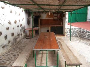 una larga mesa de madera en un edificio con un banco en Room in Guest room - Casa El Cardon A2 Buenavista del Norte, en Buenavista del Norte