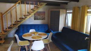 ein Esszimmer mit einem Tisch, Stühlen und einer Treppe in der Unterkunft Zielony Domek Kruklanki in Kruklanki