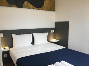 a bedroom with a large bed with blue and white sheets at ARTiSTiC GUESTHOUSE in Tomar