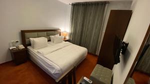- une chambre avec un lit doté de draps et d'oreillers blancs dans l'établissement Golden Rose Hotel, à Naplouse