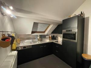 una pequeña cocina con armarios negros y fregadero en Escape at Durbuy en Durbuy