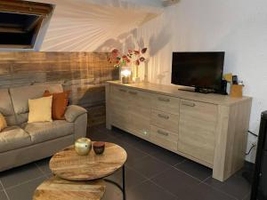 a living room with a couch and a flat screen tv at Escape at Durbuy in Durbuy