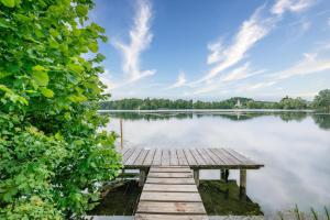 einem hölzernen Steg auf einem Wasserkörper in der Unterkunft Sopherl am See in Weßling