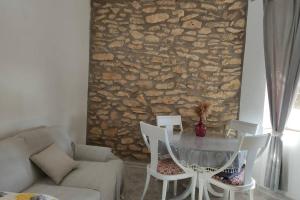 einen Tisch und Stühle in einem Wohnzimmer mit einer Steinmauer in der Unterkunft Casa Ani in Amposta