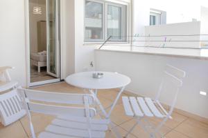 una mesa blanca y 2 sillas en una habitación en Salaqua Bed and Breakfast, en Torre Mozza