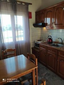 a kitchen with wooden cabinets and a table with a tea kettle at EKTOR APARTMENTS @SWIMMING POOL in Sidari