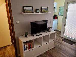 a living room with a tv on a white entertainment center at Bergstation Altenau in Altenau