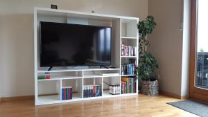 a white entertainment center with a flat screen tv at Ferienwohnung Zum Heideblick in Winterberg