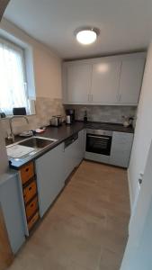 a kitchen with white cabinets and a sink at Ferienwohnung Zum Heideblick in Winterberg