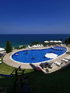 a large swimming pool with chairs and umbrellas at Silver A 27 in Byala