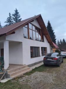 a house with a car parked in front of it at CASA DINCA in Cîmpu lui Neag