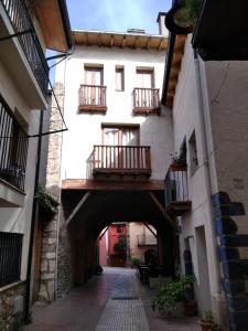 an alley way with a building with a balcony at Casa del Sol in Organyà