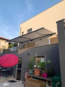 a house with a retractable umbrella on the side of it at Galeb Apartments osjecka ulica 37 in Pula