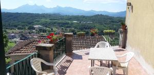 a balcony with a table and chairs and mountains at Casa sotto il Castello in Monti di Licciana Nardi