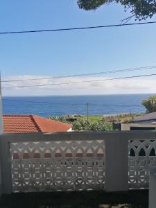 una cerca blanca con vistas al océano en Avó Lucindinha House - Porto Moniz en Porto Moniz