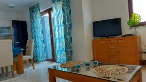uma sala de estar com uma televisão e uma mesa em SeaSight Apartment - Ciovo Island em Slatine