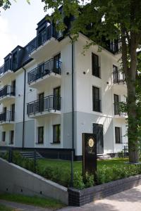 a white building with a sign in front of it at Villa 44 -V44- in Świnoujście