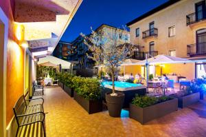eine Außenterrasse mit einem Pool sowie Tischen und Stühlen in der Unterkunft Hotel Fontana Verona in Verona