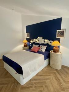 Un dormitorio con una cama azul y blanca con almohadas en El Loft de Andy, en Oviedo