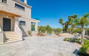 a patio with a pool and a house at Villa Olive Green in Argasi