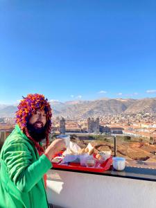 un hombre sentado en una mesa con una bandeja de comida en Hostal Casa Del Inka, en Cusco