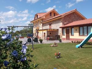 un patio con un tobogán y una casa en Vivienda Rural La Mazuga, en Cabárceno