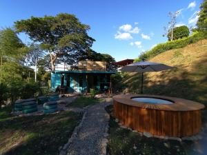 a house with a large wooden circle in the yard at Tiny House Serendipia - Caserío El Puente -Villeta in Villeta