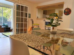 哥西爾的住宿－TROPICAL PARADISE La MARINA，一间设有玻璃桌和椅子的用餐室