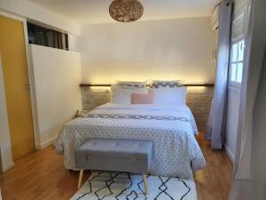 een slaapkamer met een bed met een witte sprei bij TROPICAL PARADISE La MARINA in Le Gosier