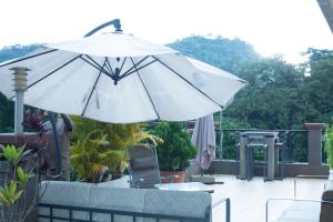 Residence MASSOU في ياوندي: وجود مظلة بيضاء جالسة فوق الفناء