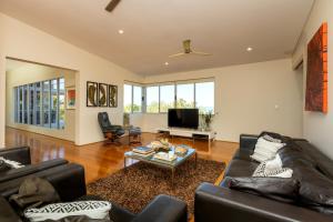 a living room with two couches and a tv at Koolinda by the Bay, Broome WA in Broome