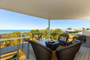 a patio with chairs and a table and the ocean at Koolinda by the Bay, Broome WA in Broome