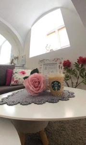 a room with a table with a pink rose on it at Korona Apartman Székesfehérvár in Székesfehérvár