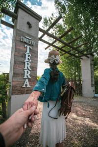 una persona sosteniendo la mano de una chica delante de un cartel en Cabañas y Habitaciones Terra Nostra Complejo en General Alvear