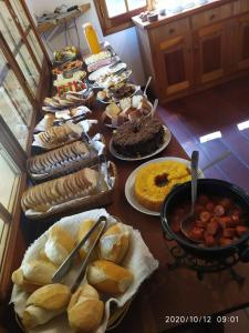 uma mesa com vários tipos diferentes de alimentos em Refúgio do Selado em Monte Verde