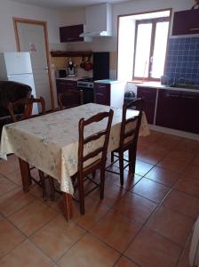 een keuken met een tafel en een aantal stoelen en een tafel en een keuken bij Plein pied dans maison de caractère in Montjaux