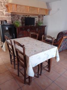 een tafel en stoelen in een woonkamer met een open haard bij Plein pied dans maison de caractère in Montjaux