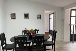 ein Esszimmer mit einem schwarzen Tisch und Stühlen in der Unterkunft en plein coeur de Talmont, maison connectée à l'esprit rétais in Talmont + 13 Fotos