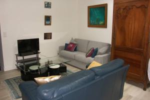 ein Wohnzimmer mit einem blauen Sofa und einem Glastisch in der Unterkunft en plein coeur de Talmont, maison connectée à l'esprit rétais in Talmont