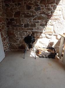 een kamer met een tafel en een stenen muur bij Plein pied dans maison de caractère in Montjaux