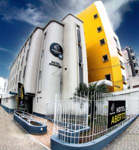 a building with a fence in front of it at Esquina Batel - Hotel Econômico in Curitiba