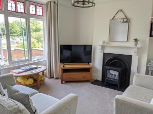a living room with a tv and a fireplace at Luxury townhouse in town centre, views, river walk in Shrewsbury