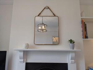 a mirror above a fireplace in a living room at Luxury townhouse in town centre, views, river walk in Shrewsbury